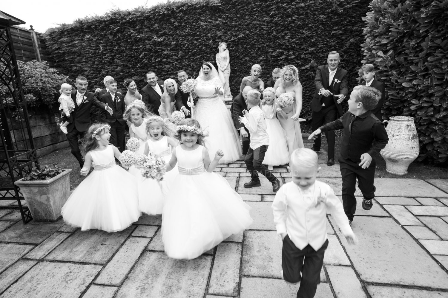 Bridal Party Runs amok! Its just as exciting as Christmas Bridal Party, Flower girl, paige boy, running, wedding photography, Yew Lodge Garden, captcha, black and white photography, reportage